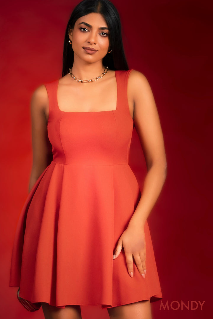 Woman wearing a red dress against a red background with 'MONDY' branding.