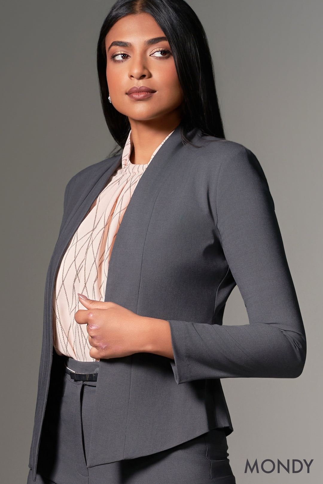 Woman wearing a gray suit with a plain background