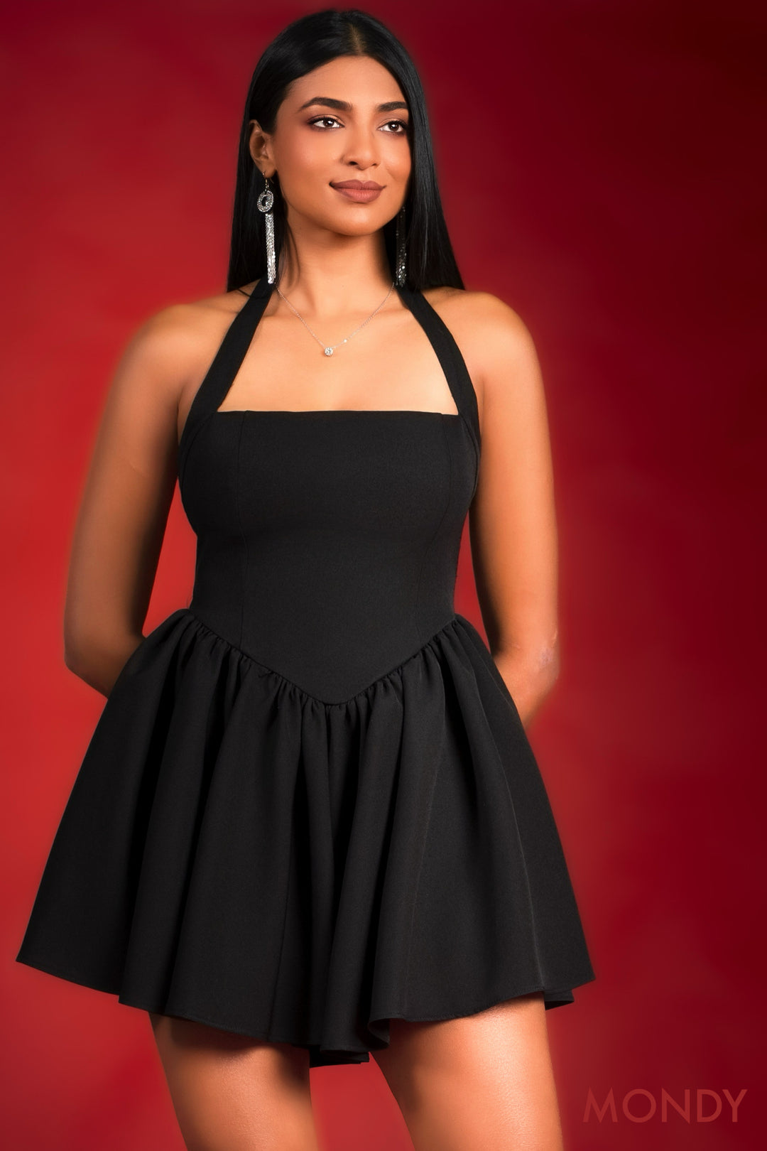 Woman wearing a black halter dress against a red background